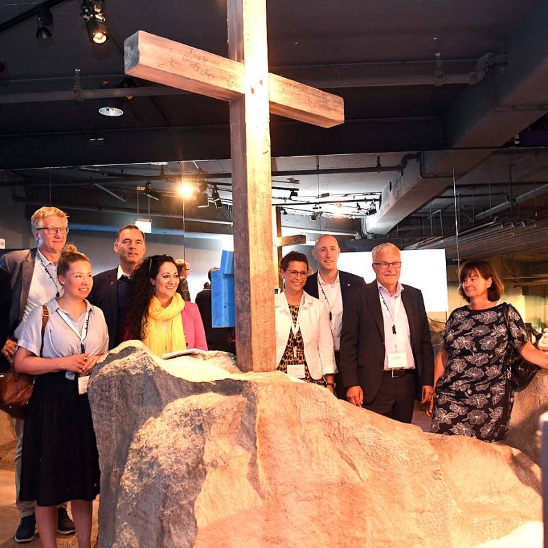 Menschengruppe vor einem Holzkreuz beim Ausflug ins Klimahaus Bremerhaven