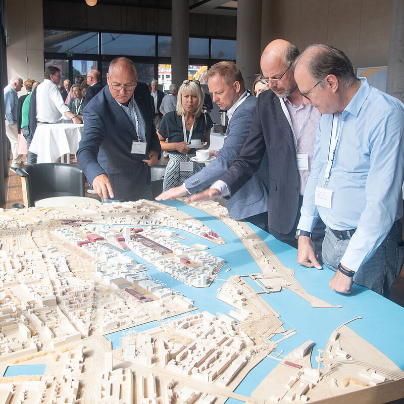 Unterschiedliche Männer die auf eine dreidimensionale Küstenkarte schauen