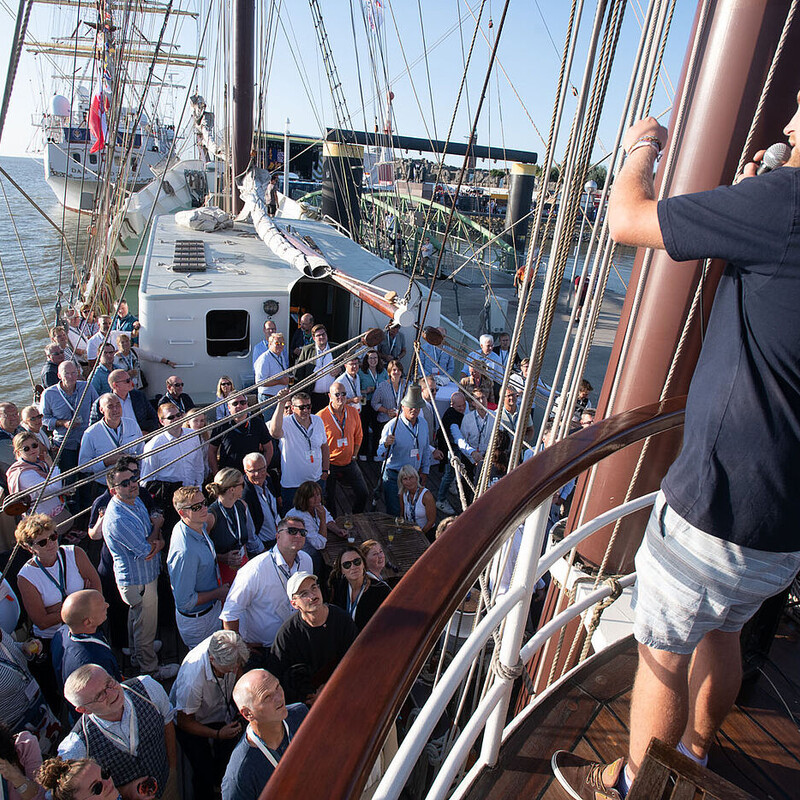 Gespannte Zuschauerschaft lauscht einem Vortrag auf einem Segelschiff