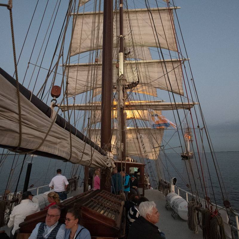 Schiffsdeck in der Abenddämmerung mit Besucher:innen des Wirtschaftsdialoges an Bord