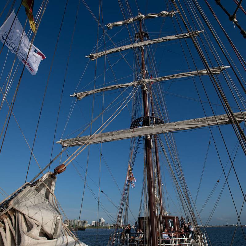 Aufnahme vom Deck eines Segelschiffes den Mast hinauf in den Himmel