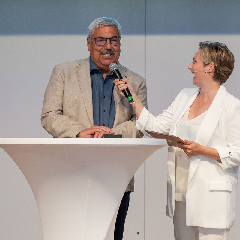 Oberbürgermeister der Stadt Bremerhaven Melf Grantz im Interview. Dargestellt ist ein Mann mittleren Alters mit weißen Haaren und eckiger Brille. Er wird gerade von einer Frau mit kurzen Haaren und einem Mikrophon in der Hand interviewt.